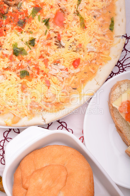 Beef pizza on white plate with red pepper