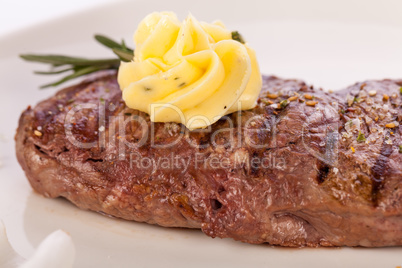 Grilled beef steak topped with butter and rosemary