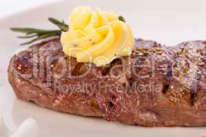 Grilled beef steak topped with butter and rosemary