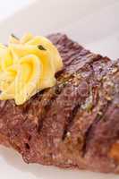 Grilled beef steak topped with butter and rosemary