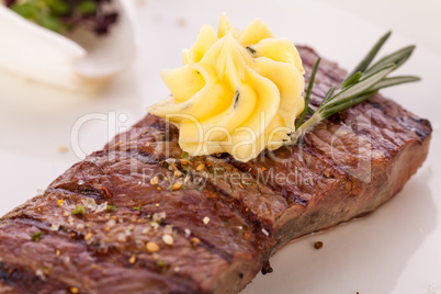 Grilled beef steak topped with butter and rosemary