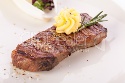 Grilled beef steak topped with butter and rosemary