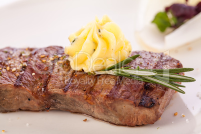 Grilled beef steak topped with butter and rosemary