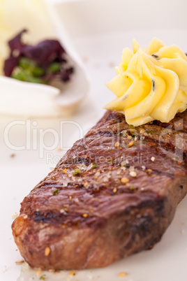 Grilled beef steak topped with butter and rosemary