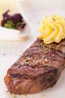 Grilled beef steak topped with butter and rosemary