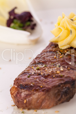 Grilled beef steak topped with butter and rosemary