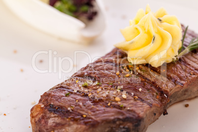 Grilled beef steak topped with butter and rosemary