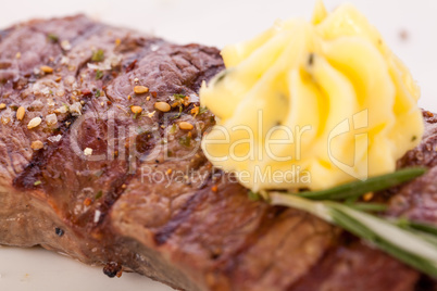 Grilled beef steak topped with butter and rosemary