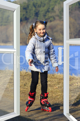 girl goes in roller skates on the ground seen from the window
