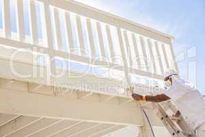 House Painter Spray Painting A Deck of A Home