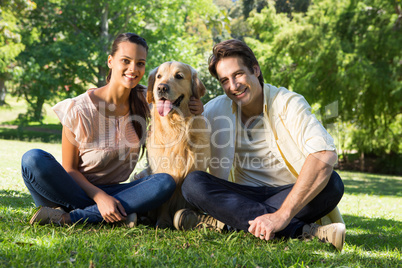 Happy couple with their pet dog in the park