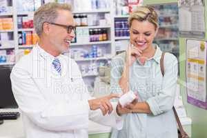 Pharmacist and customer looking at medicine