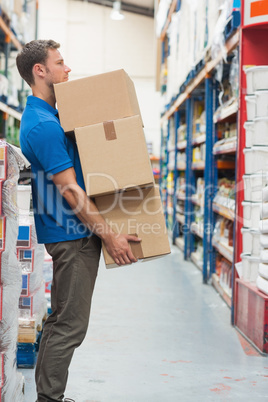 Worker carrying boxes in warehouse