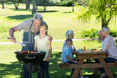 Happy father doing barbecue with his daughter