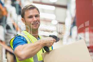 Smiling manual worker scanning package