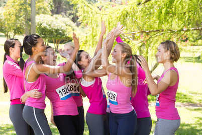 Smiling women running for breast cancer awareness