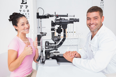 Patient gesturing thumbs up while sitting with optician