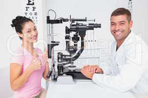 Patient gesturing thumbs up while sitting with optician
