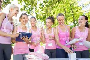 Smiling women organising event for breast cancer awareness