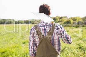 Happy farmer carrying his shovel