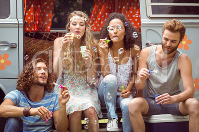 Hipsters blowing bubbles in camper van