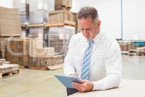 Focused boss using digital tablet