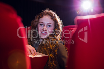 Smiling young woman watching a film