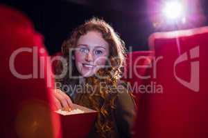 Smiling young woman watching a film