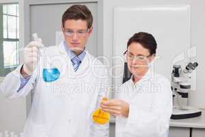 Scientists looking attentively at beakers