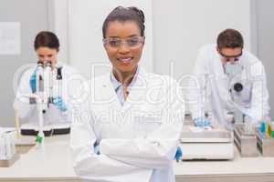 Happy scientist smiling at camera with protective glasses