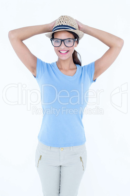 Happy brunette woman with hands on her hat