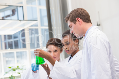 Scientists analyzing beakers with chemical fluid