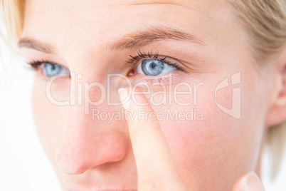 Pretty blonde applying contact lens