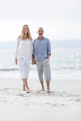 Happy couple walking by the sea