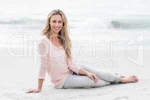 Smiling pretty blonde relaxing on the sand