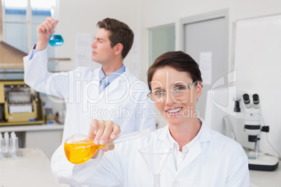 Scientists working attentively together with beakers