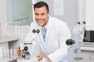 Happy scientist using microscope