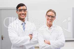 Smiling scientists looking at camera arms crossed