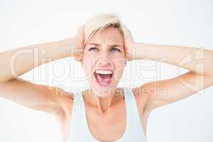 Angry blonde screaming and holding her head