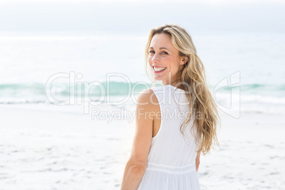 Smiling blonde in white dress looking at camera