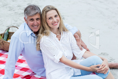 Happy couple sitting on a blanket and hugging each other