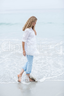 Smiling blonde walking by the sea