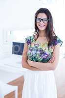 Smiling beautiful brunette standing in front of her computer