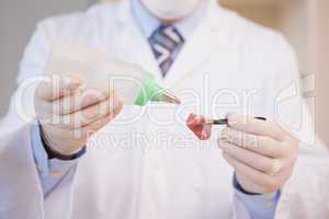 Scientist sprinkling fluid on meat