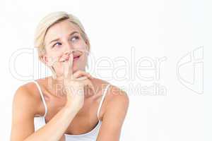 Beautiful blonde smiling with finger on mouth