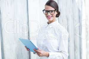 Pretty woman using her tablet pc looking at camera