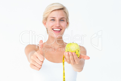 Happy woman holding an apple with thumbs up