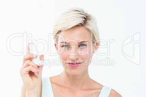 Pretty woman holding inhaler smiling at camera