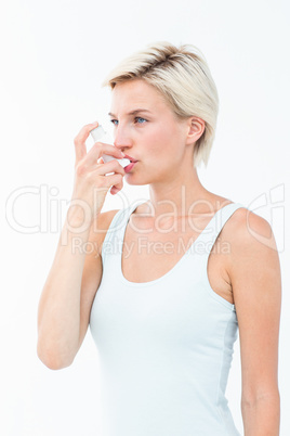 Blonde woman taking her inhaler