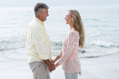 Happy couple holding hands and smiling at each other